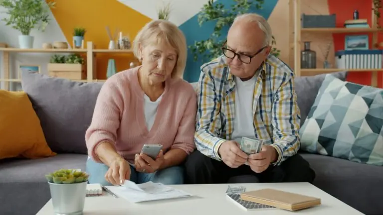 Älteres Paar sitzt auf dem Sofa und prüft gemeinsam seine Stromrechnung